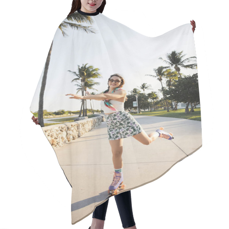 Personality  A Young Woman In Stylish Attire And Sunglasses Skates Along A Path Lined With Palm Trees In Miami. Hair Cutting Cape