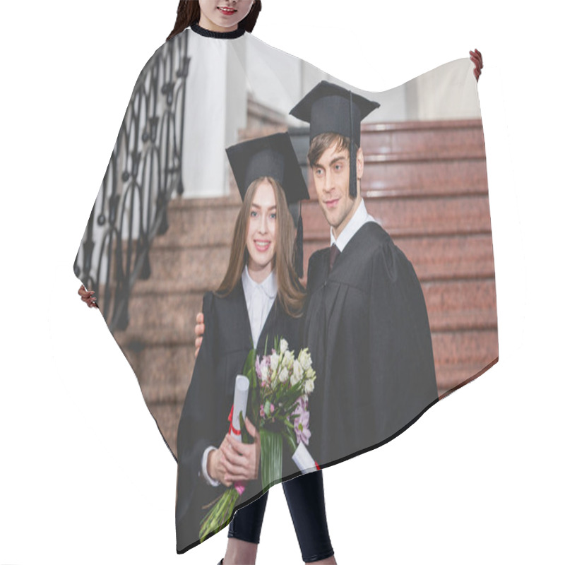 Personality  Handsome Man And Attractive Girl With Flowers Smiling While Holding Diplomas  Hair Cutting Cape