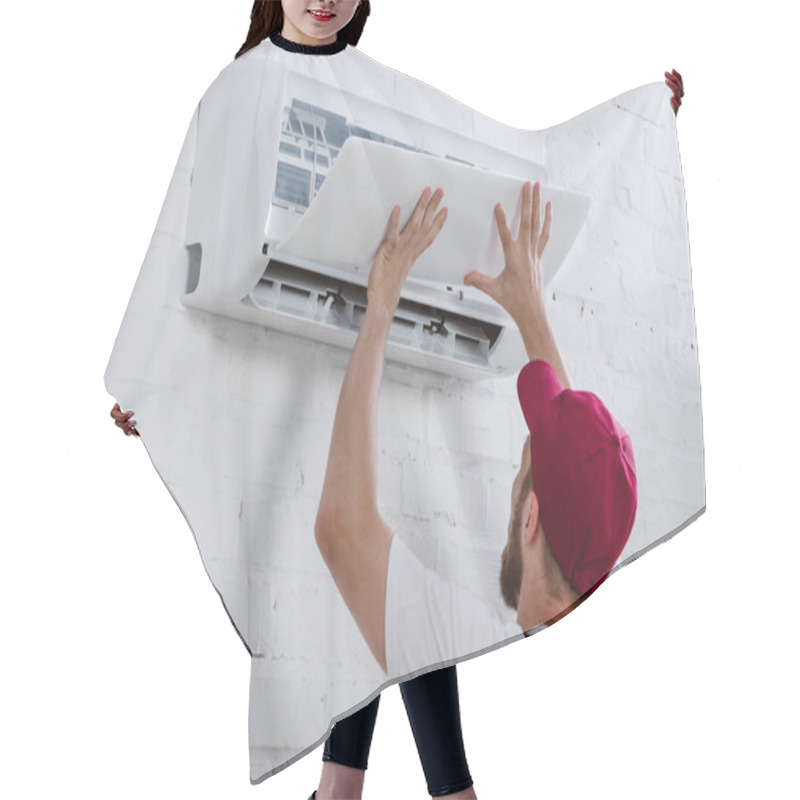 Personality  Close-up Shot Of Young Repairman Fixing Air Conditioner Hanging On White Brick Wall Hair Cutting Cape