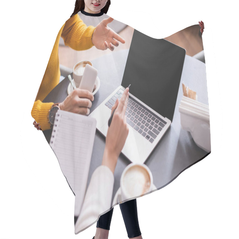 Personality  Man With Smartphone Pointing At Laptop Wit Blank Screen Near Coffee And Friend With Notebook On Blurred Foreground In Restaurant  Hair Cutting Cape