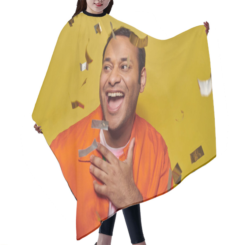 Personality  Positive Indian Man In Orange Jacket Gesturing Near Confetti On Yellow Backdrop, Party Concept Hair Cutting Cape