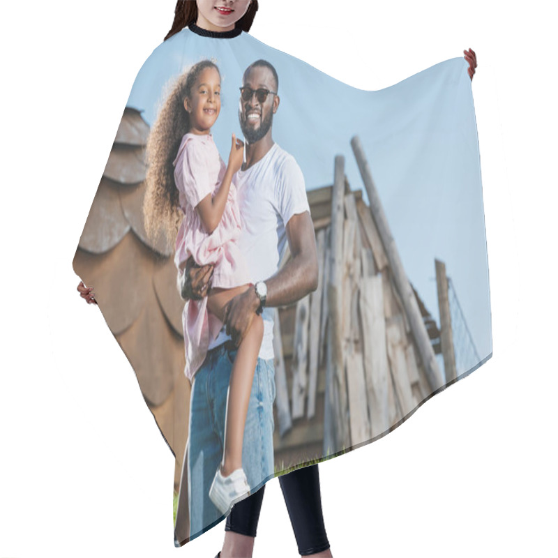 Personality  Smiling African American Father Holding Daughter On Green Hill At Amusement Park Hair Cutting Cape