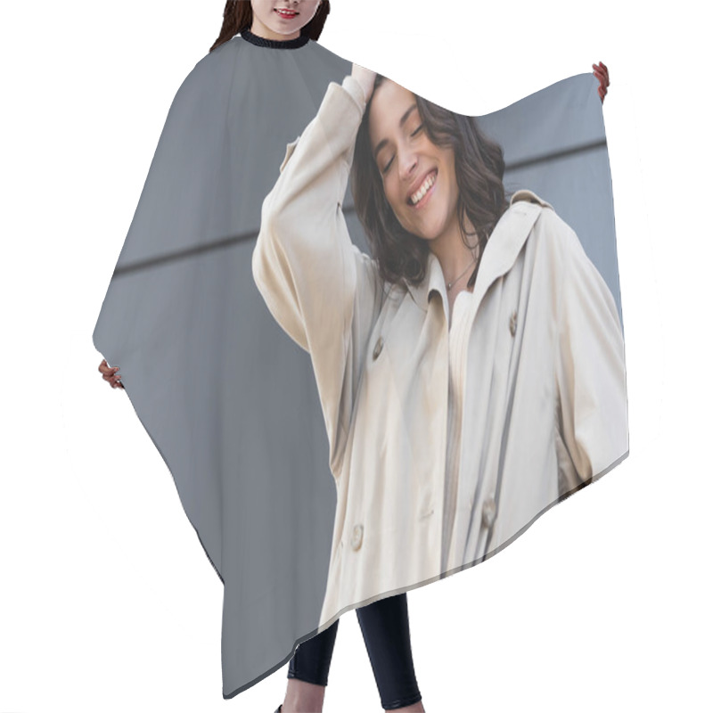 Personality  Happy Brunette Woman In Beige Raincoat Posing With Closed Eyes Near Grey Wall Hair Cutting Cape