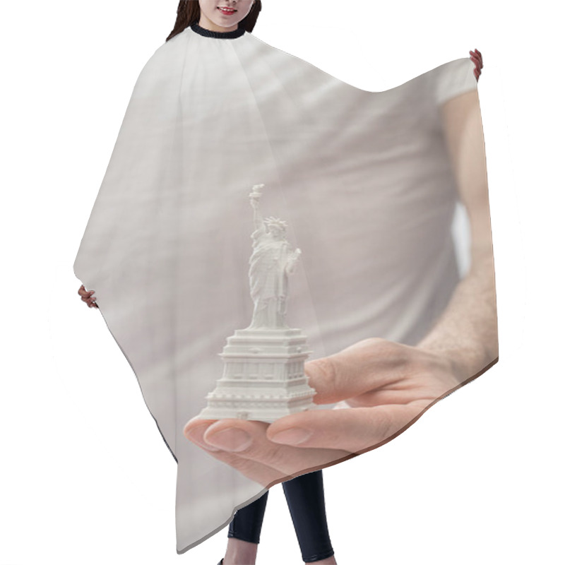 Personality  Cropped View Of Man Holding Small Statue Of Liberty  Hair Cutting Cape