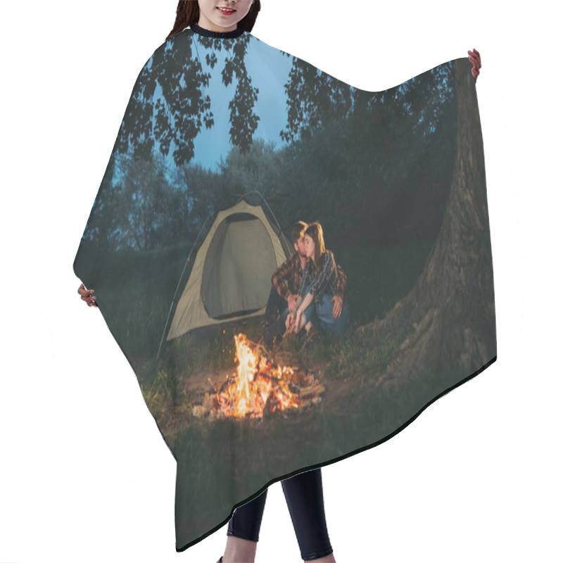 Personality  Traveler Couple In The Forest Resting By The Fire After A Working Day. Man And Woman Students Are Sitting Near The Tent. Trekking And Tourism Concept. Autumn And Evening. Place For Your Text. Hair Cutting Cape