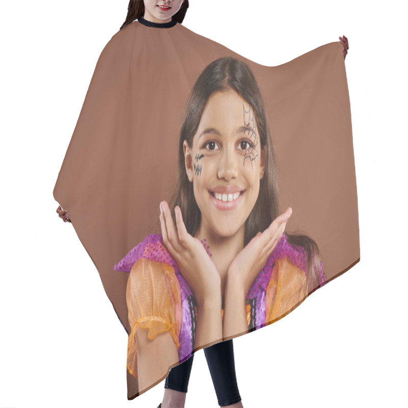 Personality  Cheerful Girl In Halloween Costume And Spiderweb Makeup Gesturing On Brown Backdrop, Trick Or Treat Hair Cutting Cape