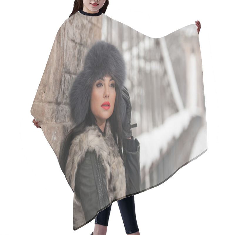 Personality  Attractive Woman With Black Fur Cap And Gray Waistcoat Enjoying The Winter. Side View Of Fashionable Brunette Girl Posing Against Snow Covered Bridge. Beautiful Young Female With Cold Weather Outfit Hair Cutting Cape