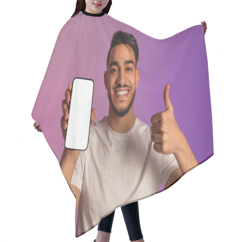 Personality  Happy Arab Man Showing Thumb Up Gesture, Demonstrating Smartphone With Empty Screen In Neon Light, Mockup Hair Cutting Cape