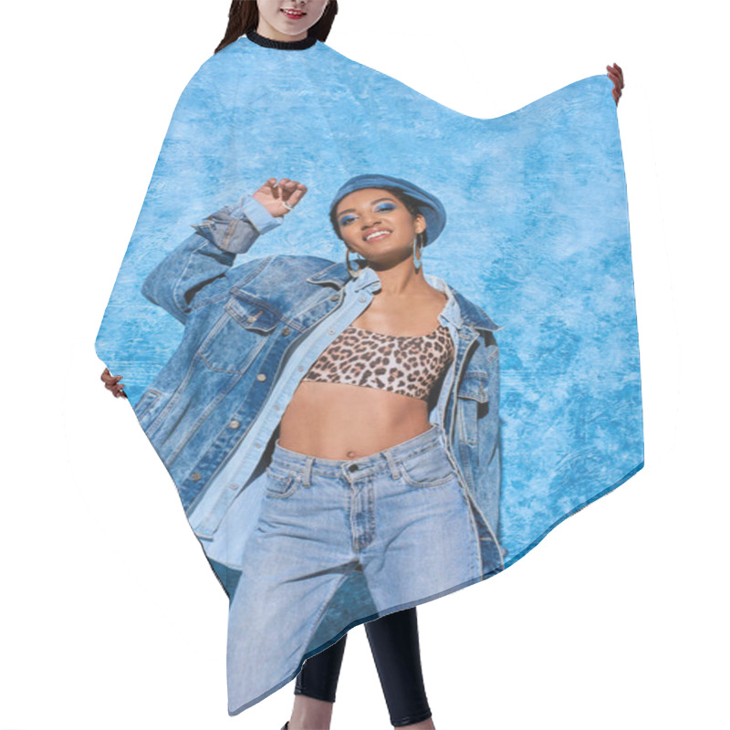 Personality  Positive African American Model With Bold Makeup Wearing Beret, Top With Animal Print And Denim Jacket While Posing And Standing Near Blue Textured Background, Stylish Denim Attire Hair Cutting Cape