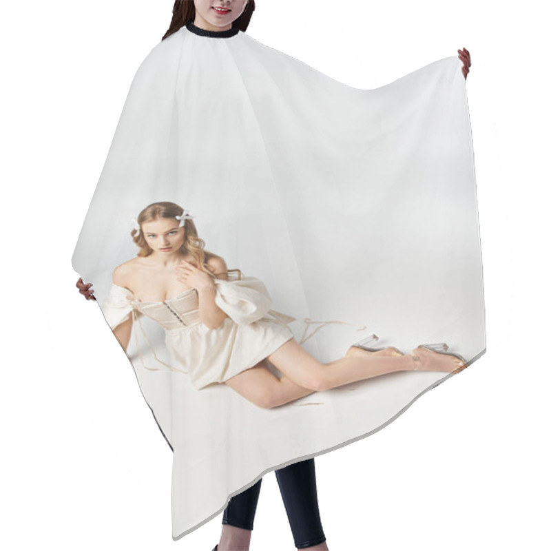 Personality  A Young Blonde Woman Wearing A Flowing White Dress Lies Gracefully On The Ground In A Serene And Elegant Pose. Hair Cutting Cape