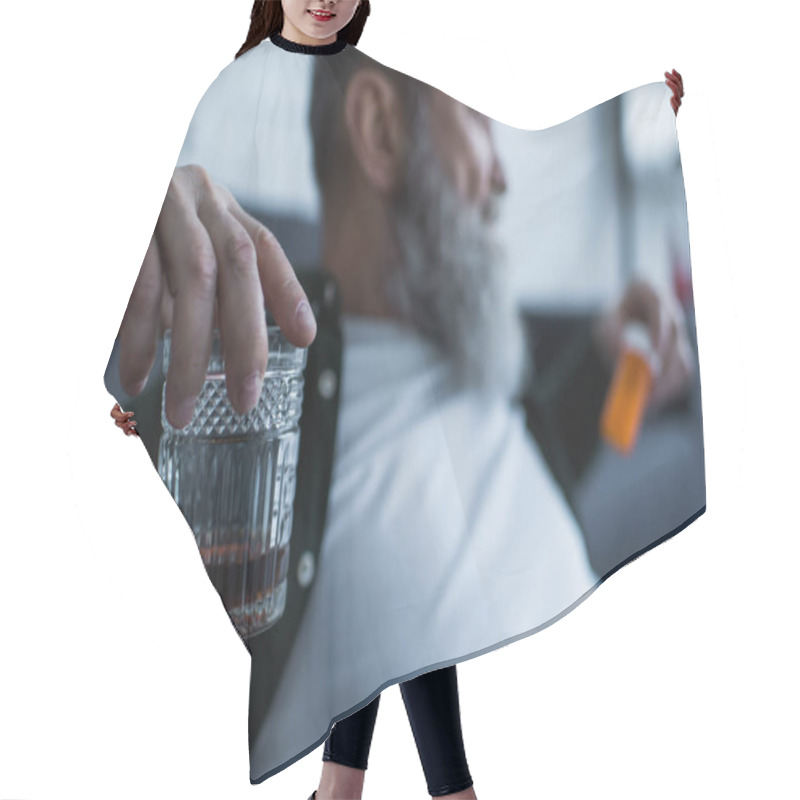 Personality  Blurred And Unhappy Senior Man Holding Glass With Whiskey And Bottle With Medication At Home Hair Cutting Cape