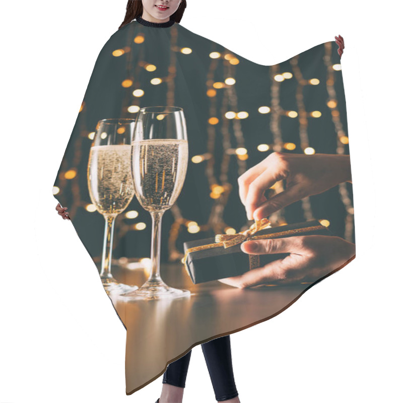 Personality  Cropped Image Of Woman Opening Present Near Champagne Glasses On Garland Light Background, Christmas Concept Hair Cutting Cape