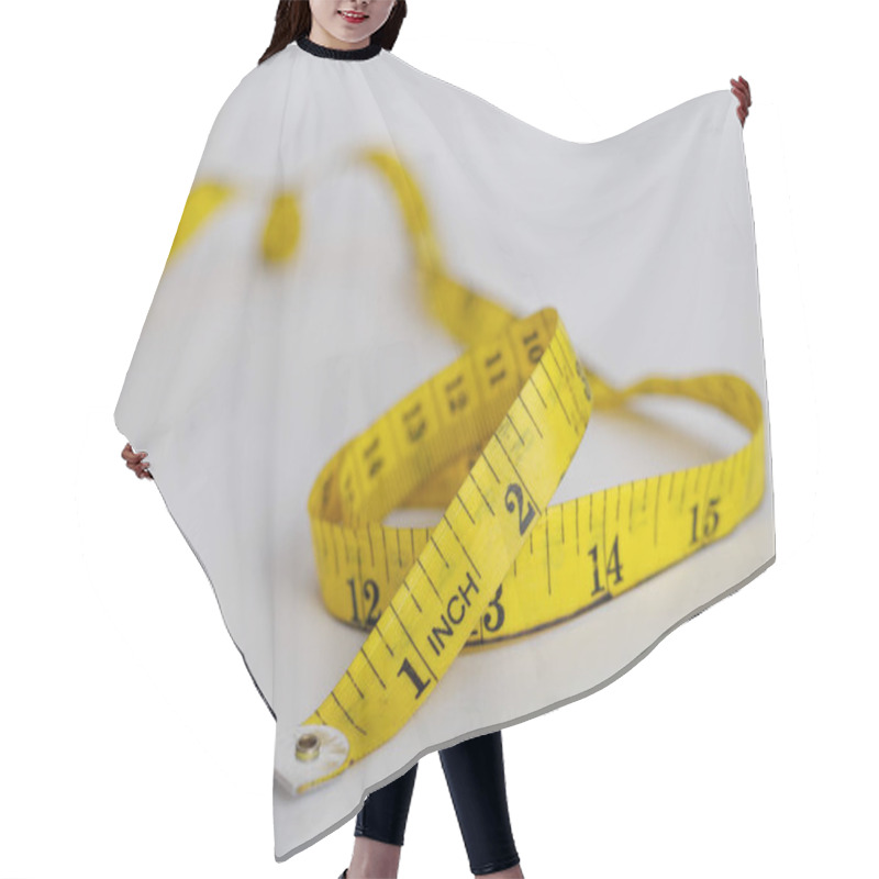 Personality  Yellow Measuring Tape With A White Background. Selective Focus. Hair Cutting Cape