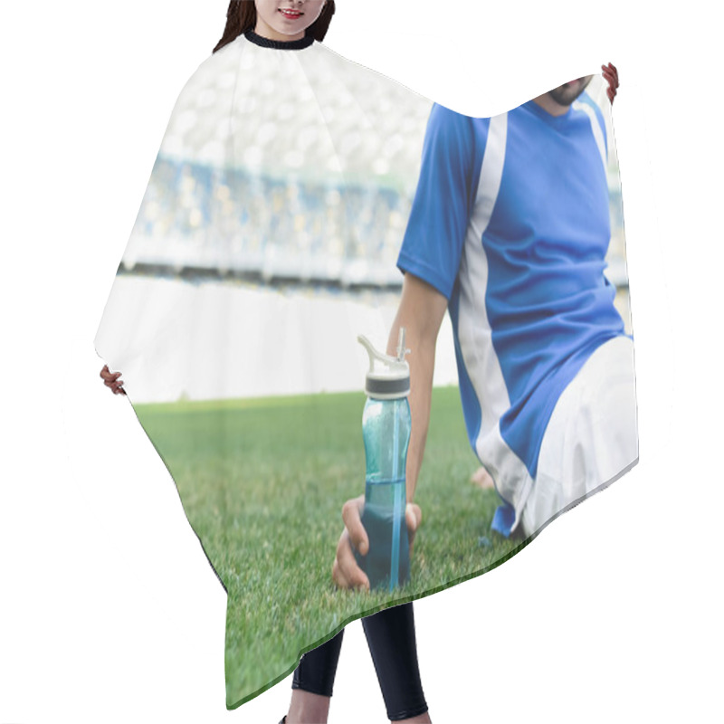 Personality  Cropped View Of Professional Soccer Player In Blue And White Uniform Sitting On Football Pitch With Sports Bottle At Stadium Hair Cutting Cape