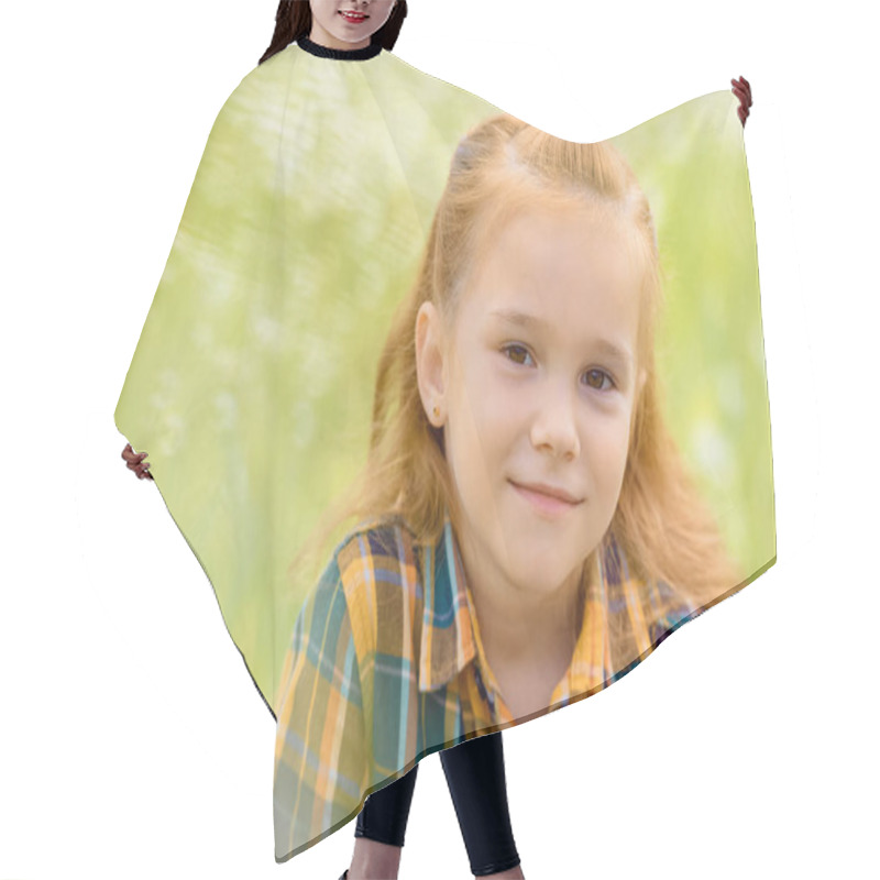 Personality  Portrait Of Adorable Kid Looking At Camera With Blurred Green Grass On Background Hair Cutting Cape