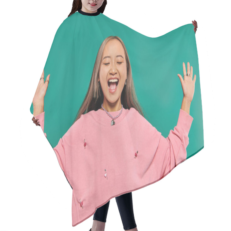 Personality  Portrait Of Excited And Young Asian Girl In Pink Sweatshirt Posing On Turquoise Background Hair Cutting Cape