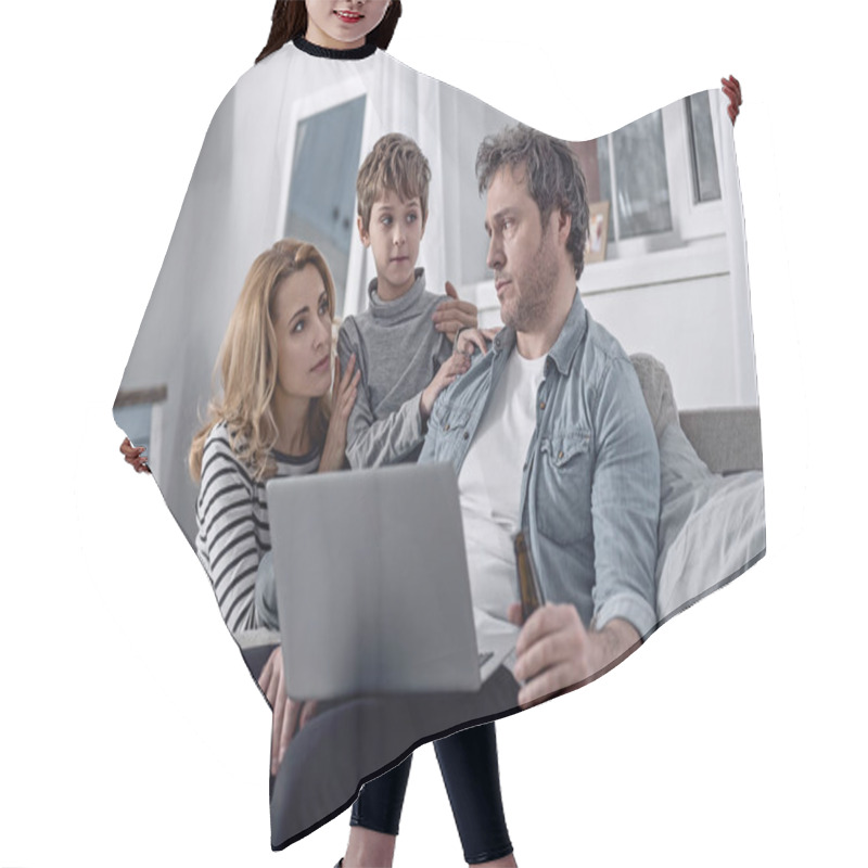 Personality  Depressed Man Sitting With A Laptop And His Family Members Sitting Near Hair Cutting Cape