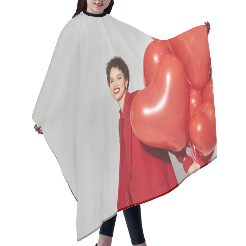 Personality  A Young Woman Dressed In Striking Red Smiles Broadly While Playfully Holding Heart Shaped Balloons. Hair Cutting Cape