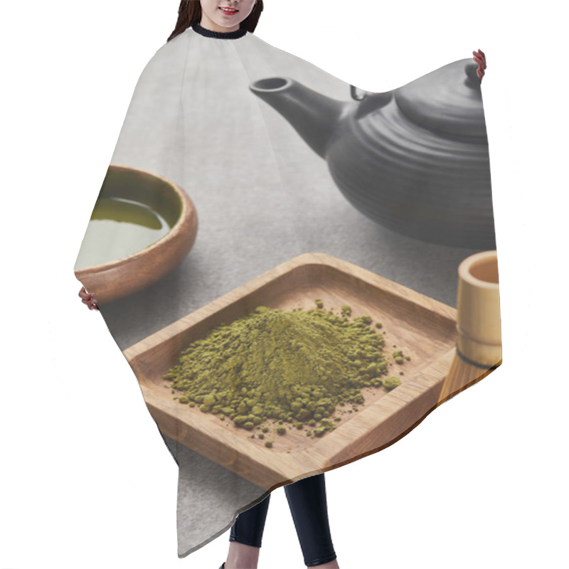 Personality  Selective Focus Of Green Matcha Powder And Bamboo Whisk On Wooden Board Near Black Teapot And Bowl With Tea Hair Cutting Cape