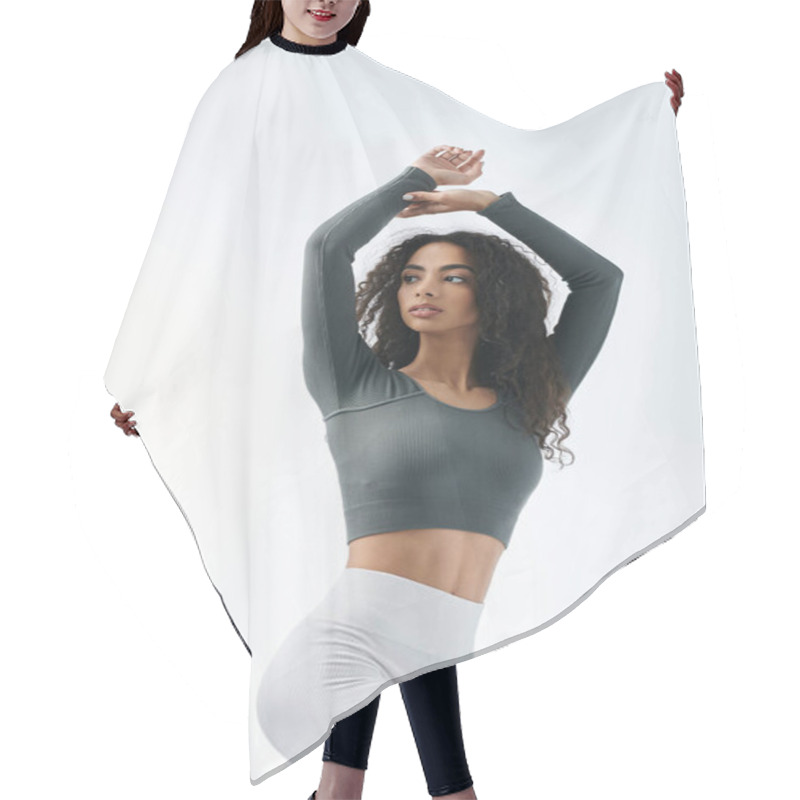 Personality  A Young Woman In Athletic Wear Stretches Her Arms Above Her Head In A Studio Setting. Hair Cutting Cape