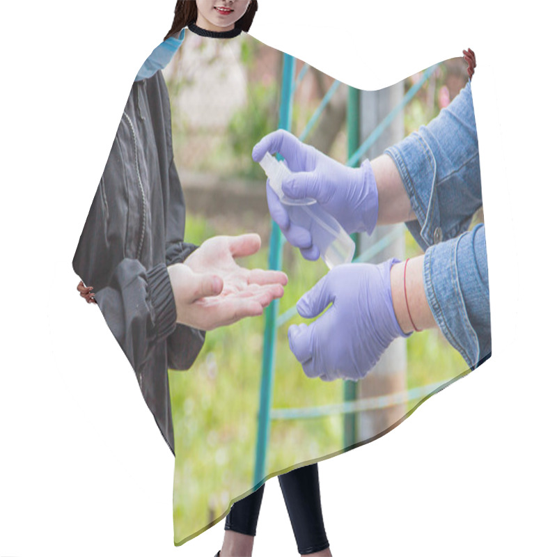 Personality  A Grandmother In A Medical Mask And Gloves Disinfects The Hands Of Her Grandson With A Sanitizer During An Epidemic Of The Coronavirus Virus, Influenza. Virus Protection During Illness And Coughing Hair Cutting Cape