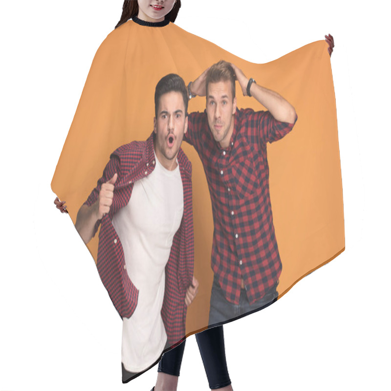 Personality  Best Friends Having Fun At Studio. Two Men Making Funny Face, Posing On Orange Studio Background. Hair Cutting Cape