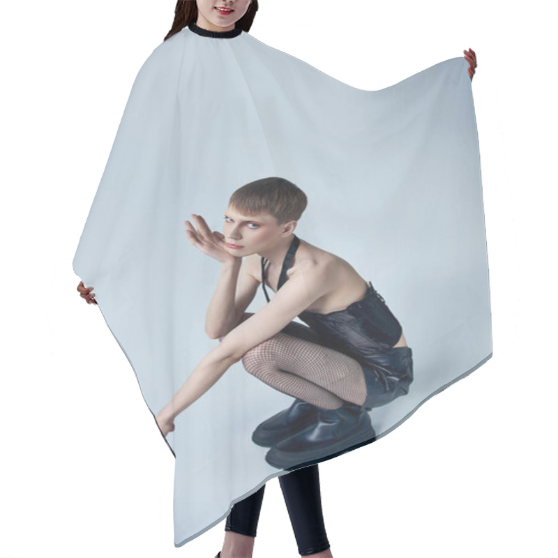 Personality  Model In Black Corset And Shorts Sitting On Grey Backdrop, Androgynous Person, Queer Fashion Hair Cutting Cape