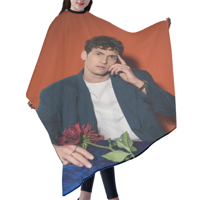 Personality  Stylish Man Touching Forehead Near Burgundy Dahlia Flower On Red Background Hair Cutting Cape