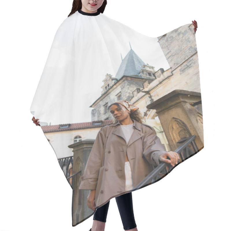 Personality  Low Angle View Of Stylish African American Woman In Trench Coat Near Old Town Hall Tower In Prague Hair Cutting Cape