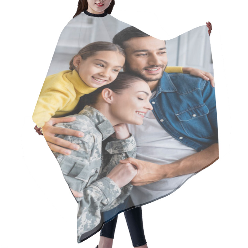 Personality  Positive Woman In Military Uniform Holding Hand Of Husband Near Kid At Home  Hair Cutting Cape