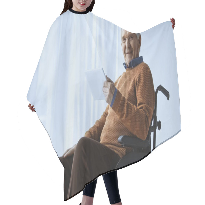 Personality  Cheerful Pensioner In Wheelchair Holding Tablet In Hand At Retirement Home Hair Cutting Cape