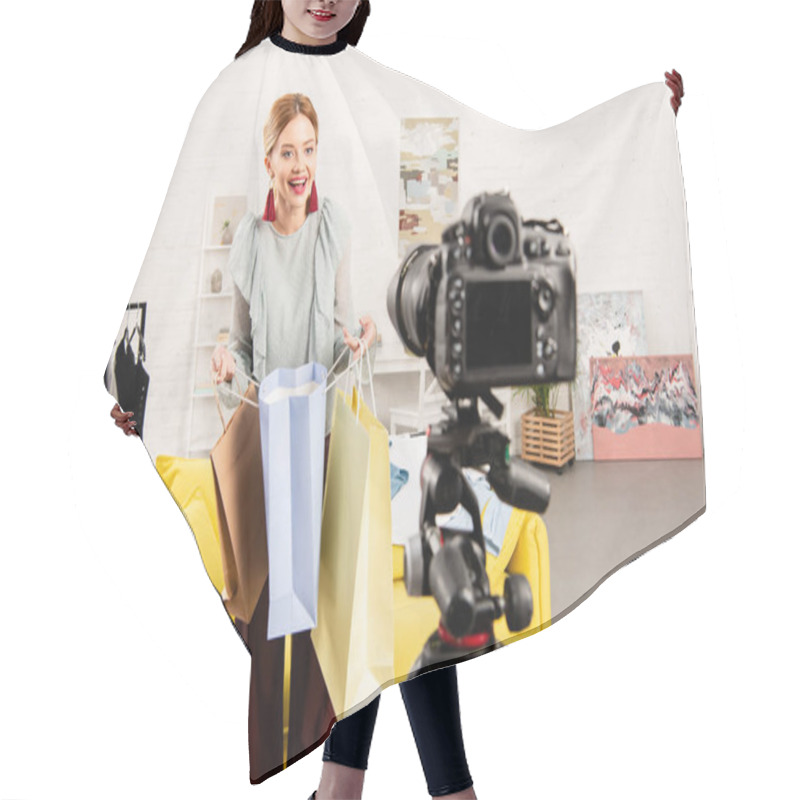 Personality  Smiling Blogger Holding Shopping Bags In Front Of Video Camera At Home Hair Cutting Cape