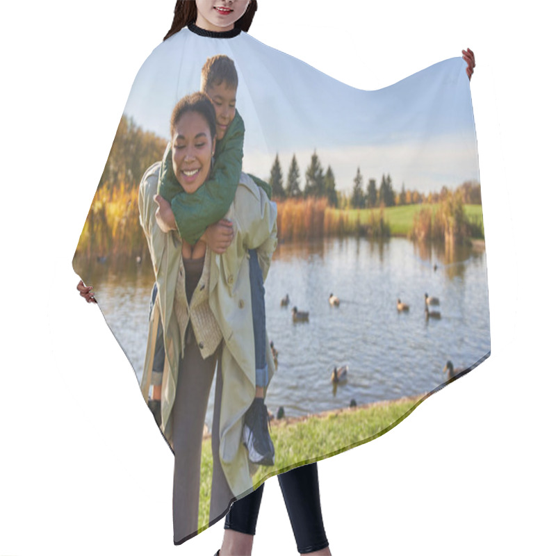 Personality  Positive Mother Piggybacking Son Near Pond With Ducks, Childhood, African American, Autumn, Candid Hair Cutting Cape