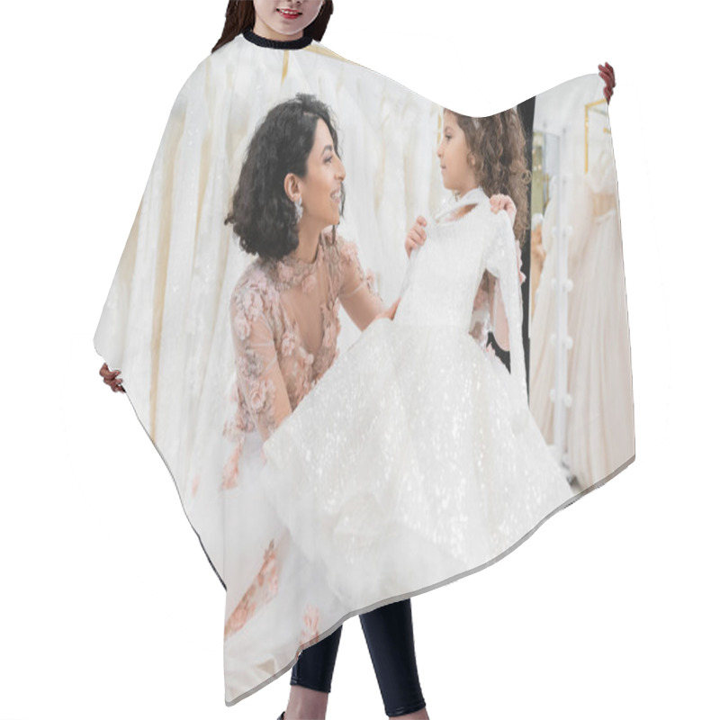 Personality  Happy And Brunette Middle Eastern Woman In Floral Wedding Gown Helping To Choose White Dress For Her Little Daughter In Bridal Salon Around Tulle Fabrics, Process Of Preparation  Hair Cutting Cape