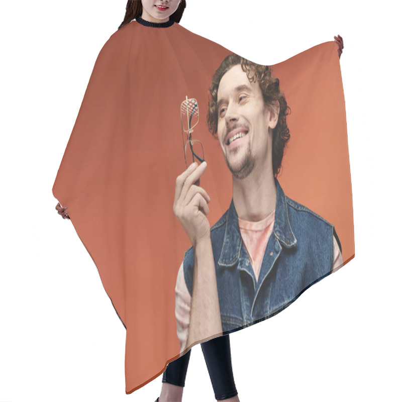 Personality  A Charming Man Enjoys A Moment, Smiling And Holding Glasses Against A Bright Background. Hair Cutting Cape