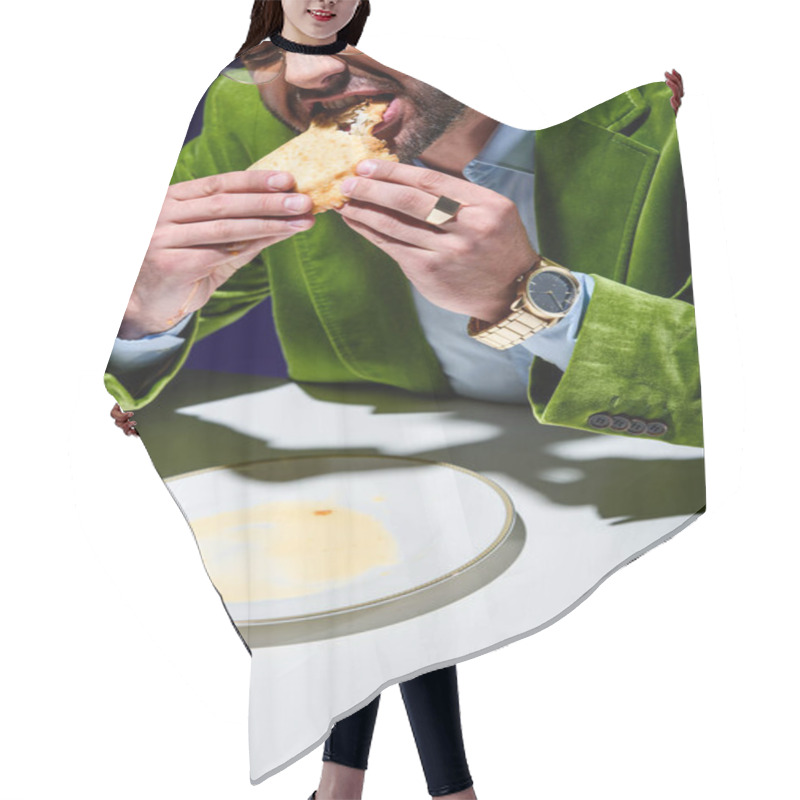 Personality  Cropped Shot Of Man In Stylish Green Velvet Jacket Eating Cheburek At Table With Blue Background Behind Hair Cutting Cape