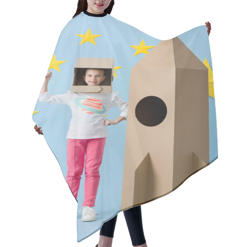 Personality  Inspired Kid In Helmet Gesturing Near Cardboard Rocket On Blue Starry Background Hair Cutting Cape