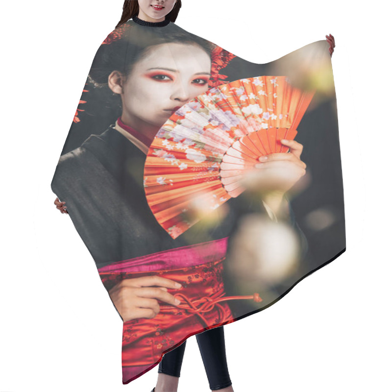 Personality  Selective Focus Of Beautiful Geisha In Black Kimono With Flowers In Hair Holding Hand Fan And Sakura Branches Isolated On Black Hair Cutting Cape