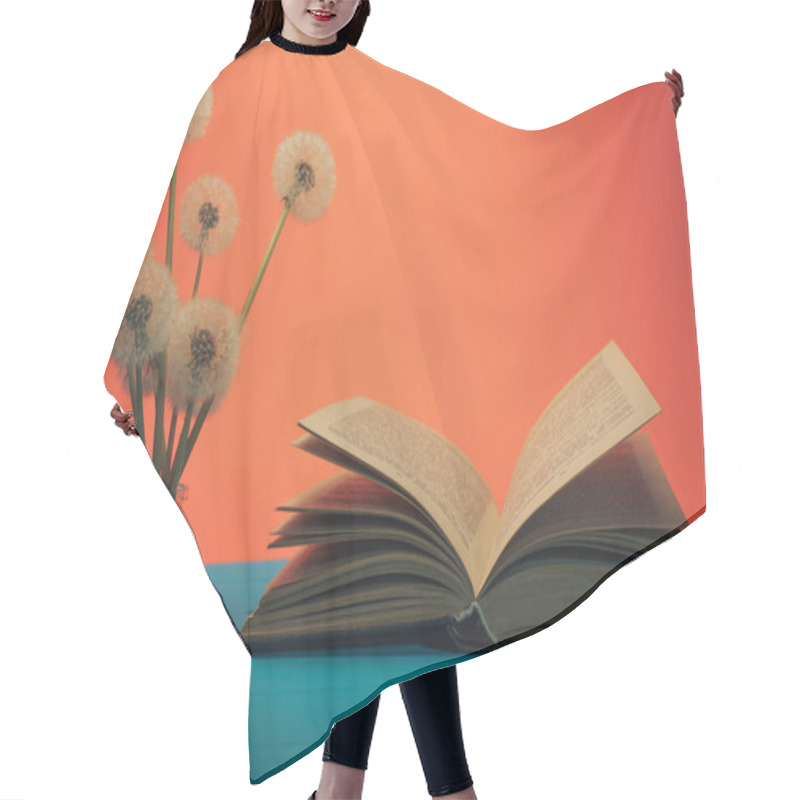 Personality  Open Book  Flower Dandelion In Vase On A Blue Wooden Table And Coral Orange Background. Hair Cutting Cape