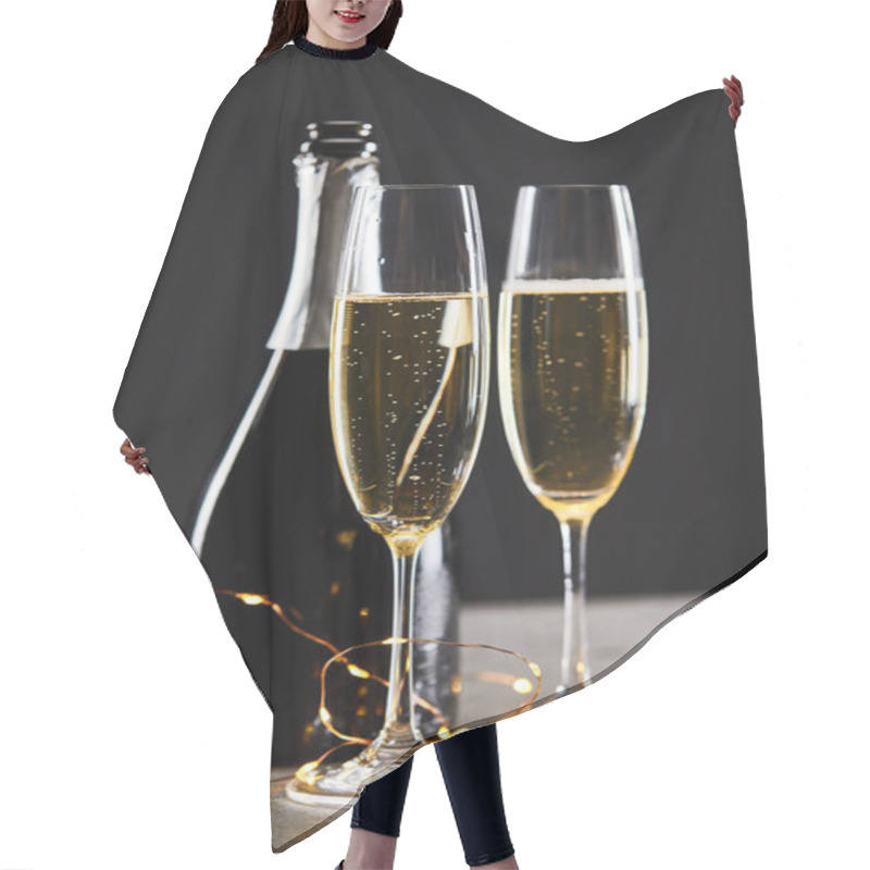 Personality  Sparkling Wine In Glasses And Bottle With Yellow Christmas Lights, On Black Hair Cutting Cape