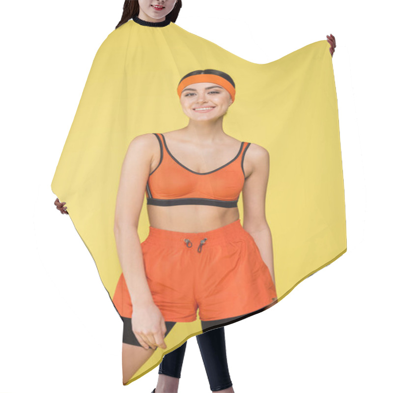 Personality  Young Woman In Orange Sportswear Smiling At Camera Isolated On Yellow Hair Cutting Cape