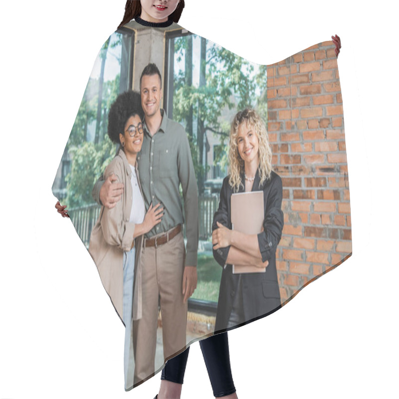 Personality  Successful Realtor With Folder And Cheerful Multiethnic Couple Looking At Camera In New Cottage Hair Cutting Cape