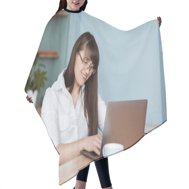 Personality  Beautiful Young Girl Working At The Computer In The Kitchen. A Girl In Glasses And A White Shirt Checks Her Mail And Drinks Coffee Hair Cutting Cape