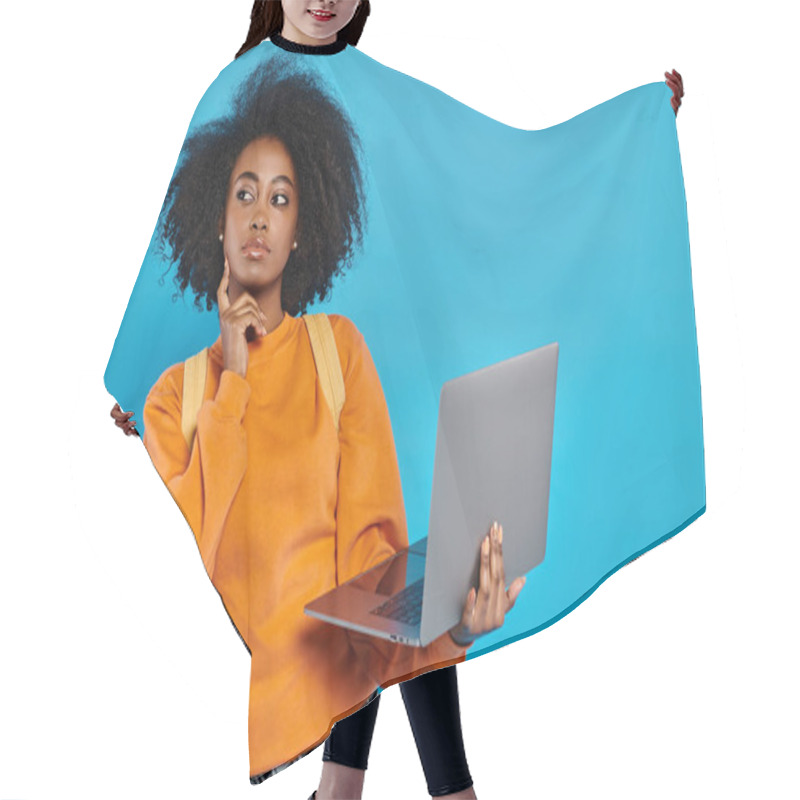 Personality  African American College Girl In Casual Attire Standing With Laptop In Front Of Blue Background. Hair Cutting Cape