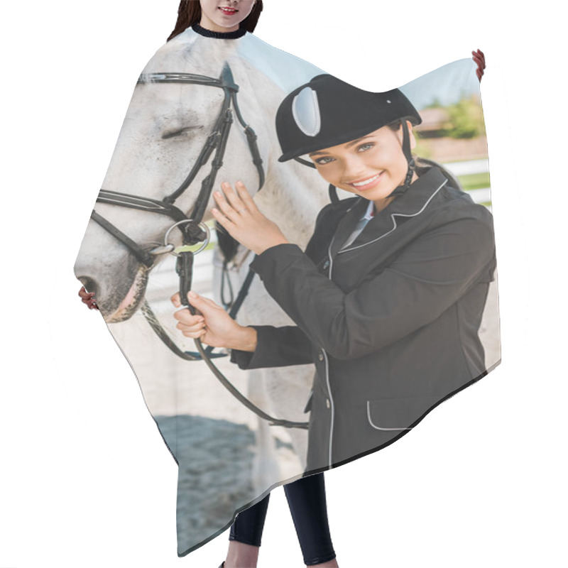 Personality  Attractive Female Equestrian In Riding Helmet Looking At Camera Near White Horse At Horse Club Hair Cutting Cape