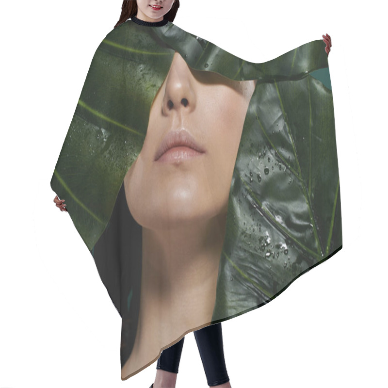 Personality  A Womans Face Framed By Large, Vibrant Green Leaves, With Water Droplets On The Leaves. Hair Cutting Cape