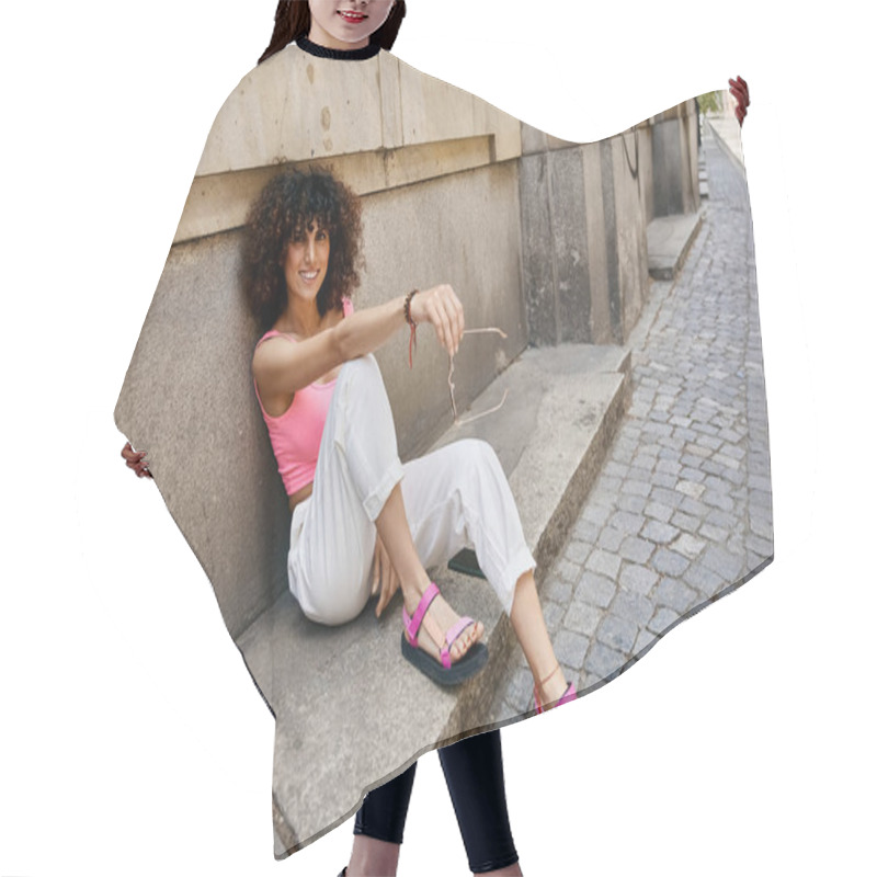 Personality  A Woman In Stylish Attire Enjoys A Summer Afternoon In A European City, Sitting On A Step In A Cobblestone Alleyway. Hair Cutting Cape