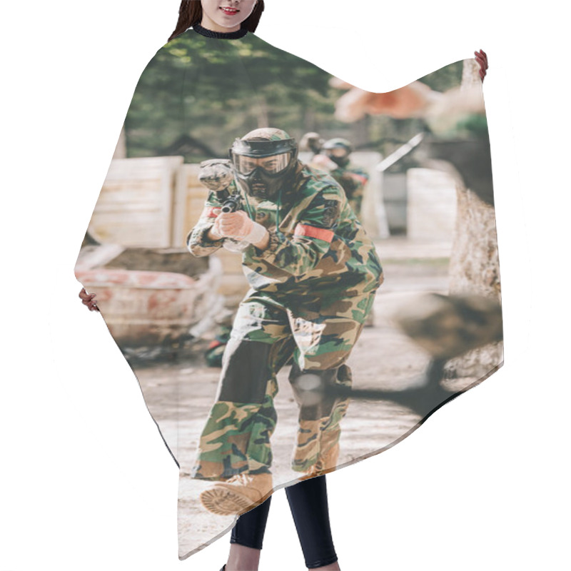 Personality  partial view of paintball player in uniform doing follow me gesture to his team outdoors hair cutting cape