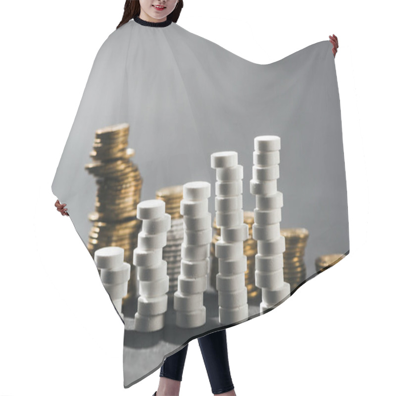 Personality  Selective Focus Of Arranged Stacks Made Of White Pills And Coins On Grey Hair Cutting Cape