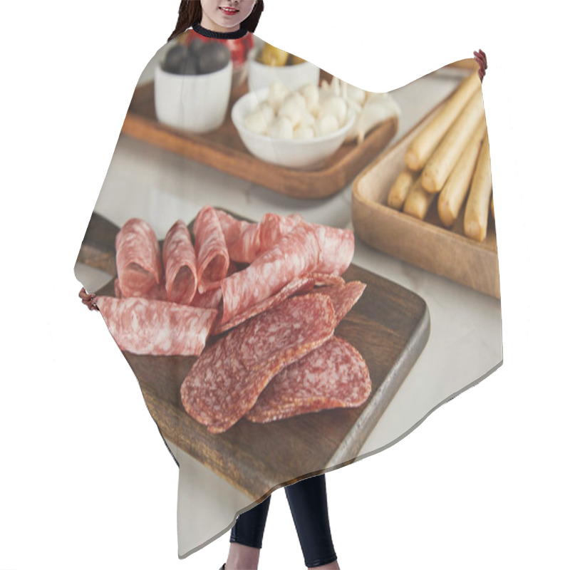 Personality  Selective Focus Of Salami Slices On Board Near Antipasto Ingredients On White Hair Cutting Cape